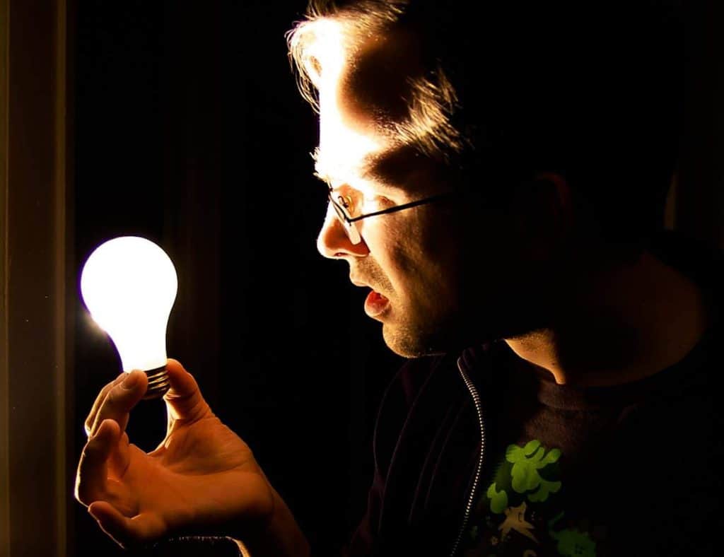 Man holding lightbuld. Procurement improvement requires enlightenment