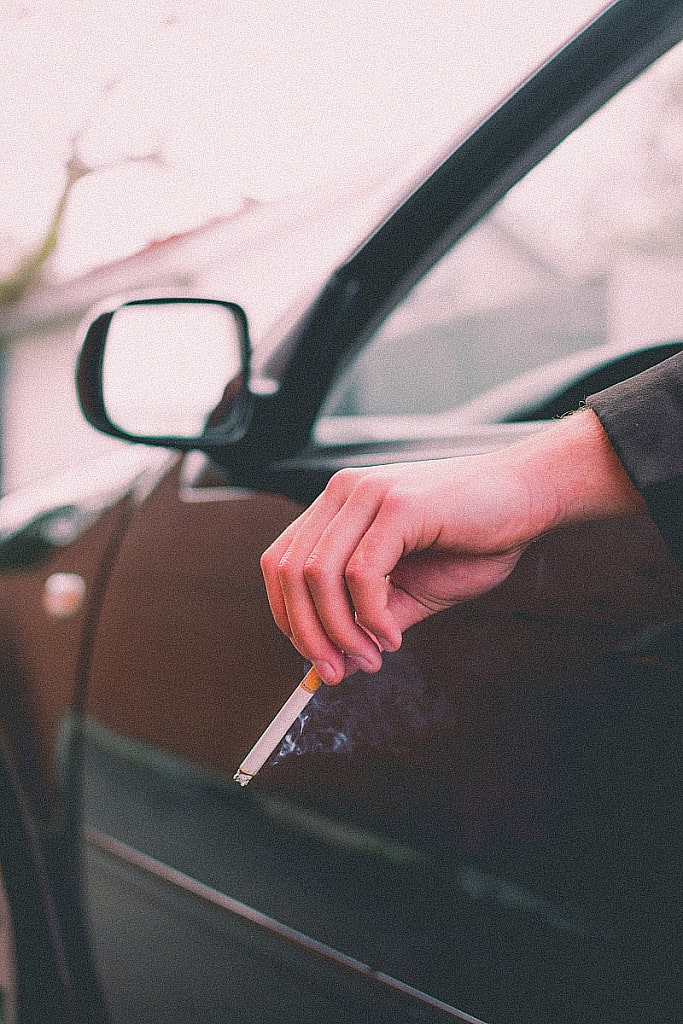 Cigarette in hand outside car window